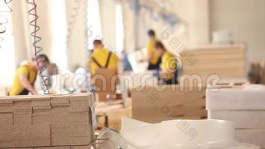 家具厂工人穿黄色工作服，收集家具，家具制造，工业内部，小深度。